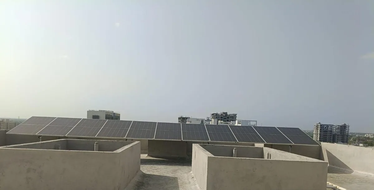 Completed rooftop solar array in Ankodiya Vadodara with clear space around raised parapet structures