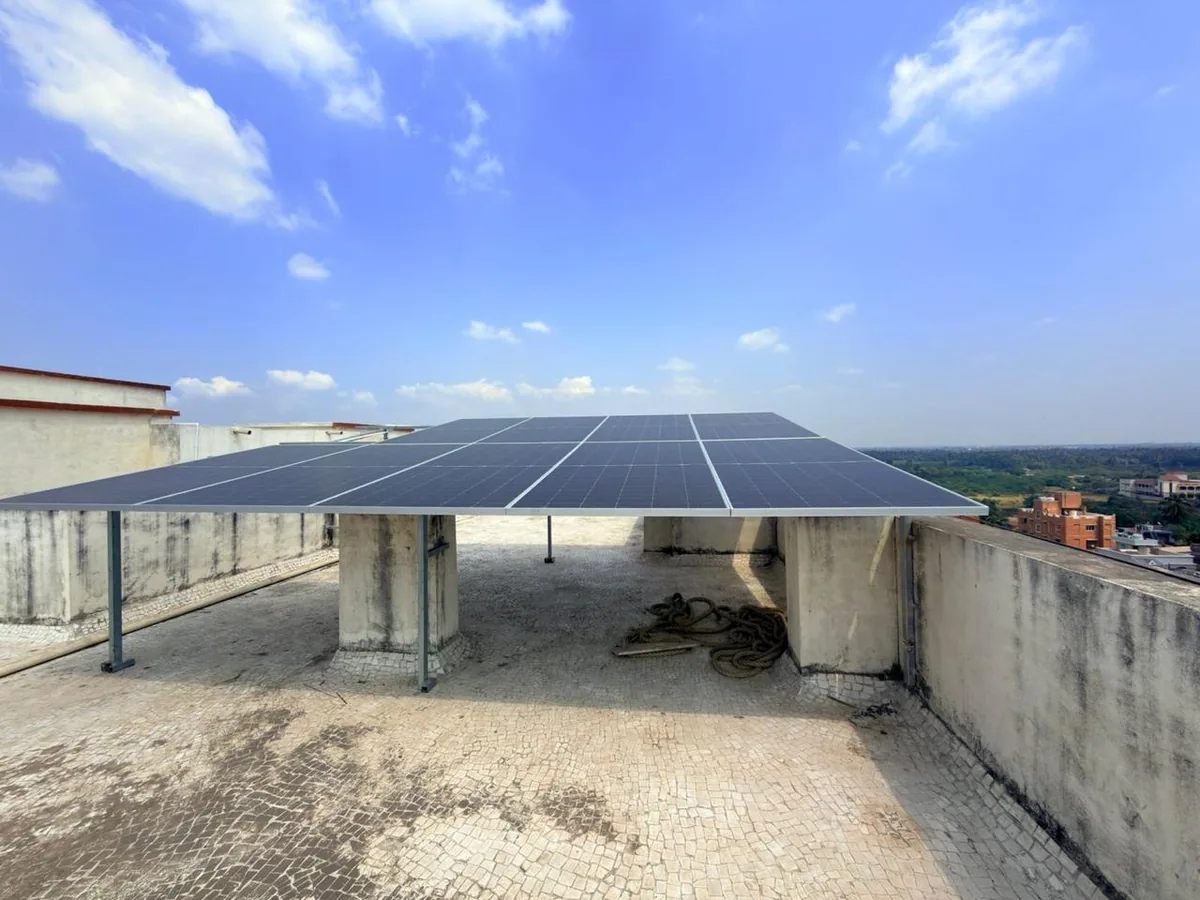 Completed rooftop solar array with a broad blue sky and clear access around the mounting structure