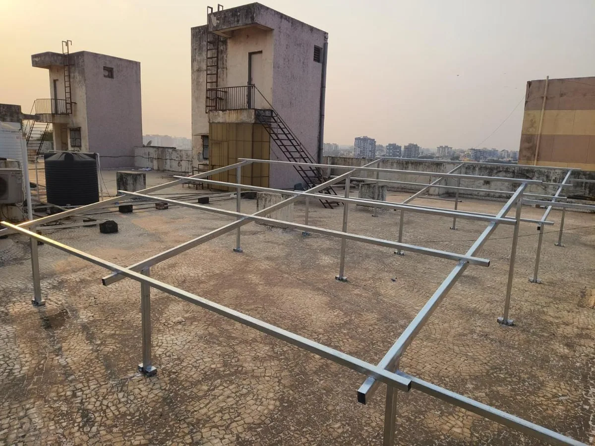 Galvanised steel solar mounting structure under construction on a rooftop at sunset